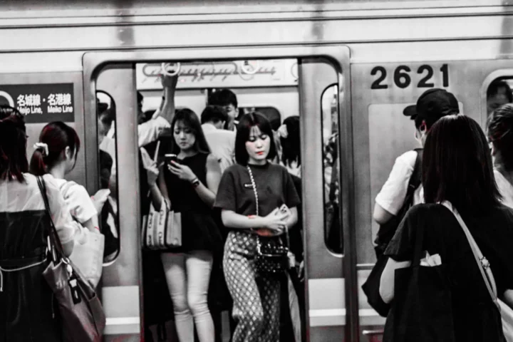A single commuter highlighted in color among the crowd.   -Uma única passageira em destaque em cor na multidão.